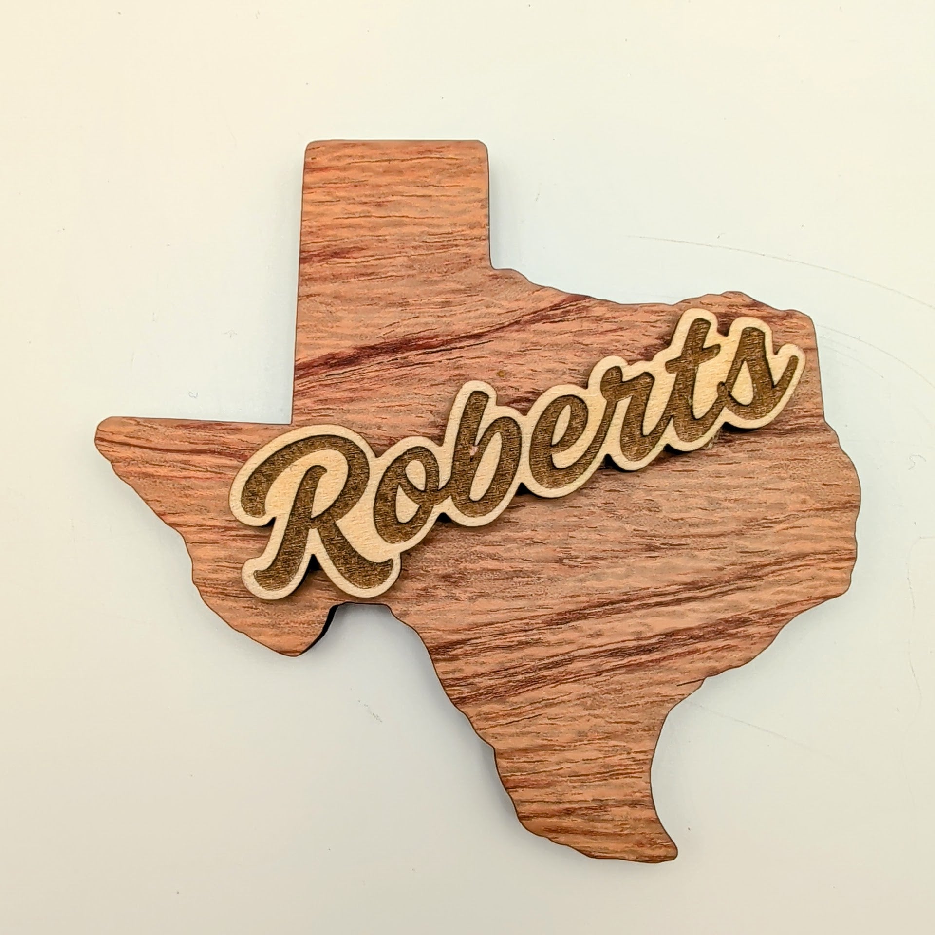 Close-up of the Signature Texas magnet showing layered walnut and basswood