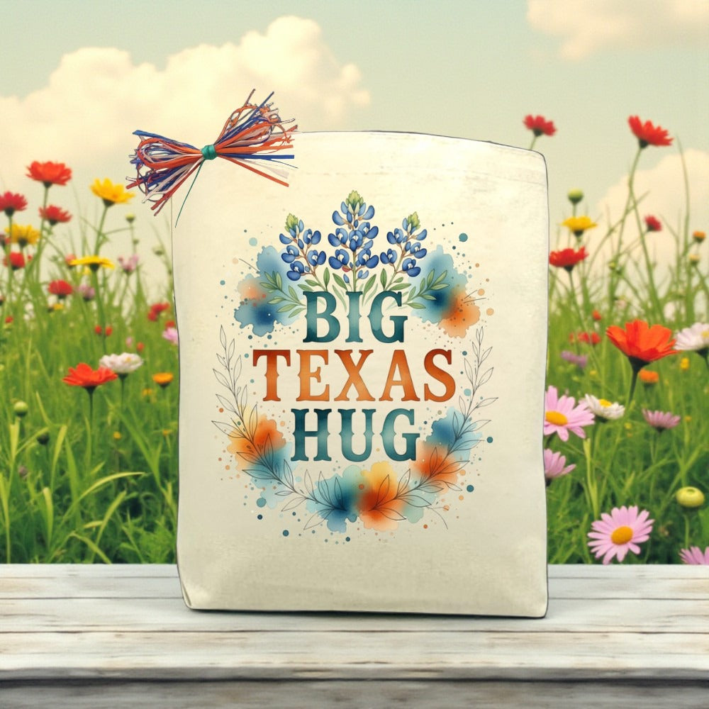 Big Texas Hug canvas gift bag with bluebonnet floral artwork, Texas-themed gift packaging displayed outdoors