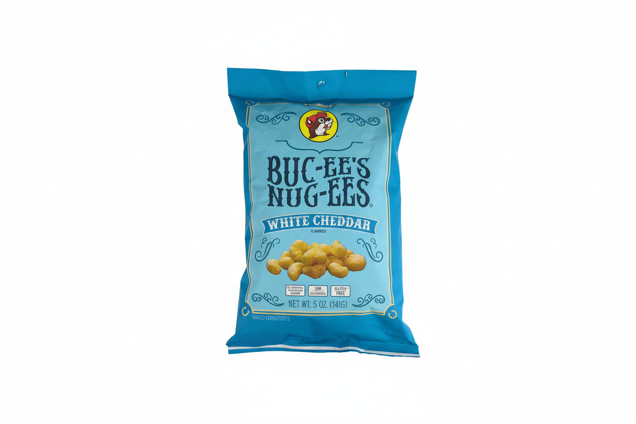 Bag of Buc-ee’s Nug-EEs white cheddar flavored baked corn puffs in a blue package, shown front-facing on a white rustic wooden background with product branding and size clearly visible.