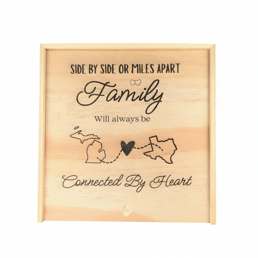 Wooden keepsake box engraved with the phrase “Side by side or miles apart, family will always be connected by heart,” featuring state outlines connected by a heart, symbolizing long-distance family love.