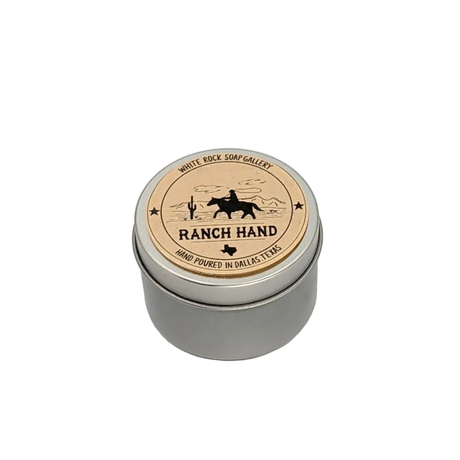 Silver metal tin candle labeled “Ranch Hand” by White Rock Soap Gallery, featuring a cowboy on horseback illustration and hand poured in Dallas, Texas, photographed on a white background.