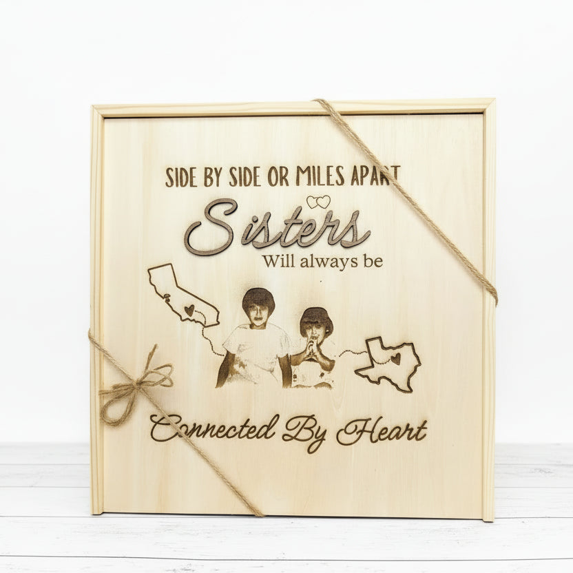 Personalized wooden keepsake box engraved with the phrase “Side by side or miles apart, sisters will always be connected by heart,” featuring a custom photo engraving, state outlines, and twine accents symbolizing long-distance sisterhood.