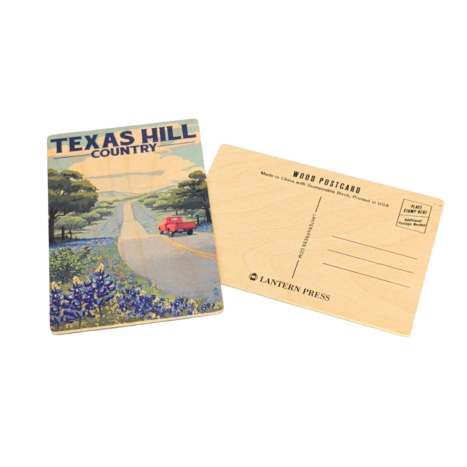 Front and back view of a Texas Hill Country wooden postcard showing a scenic country road lined with bluebonnets, trees, and a red pickup truck driving through rolling hills, paired with a natural birch wood postcard back featuring address lines and Lantern Press branding on a white background.
