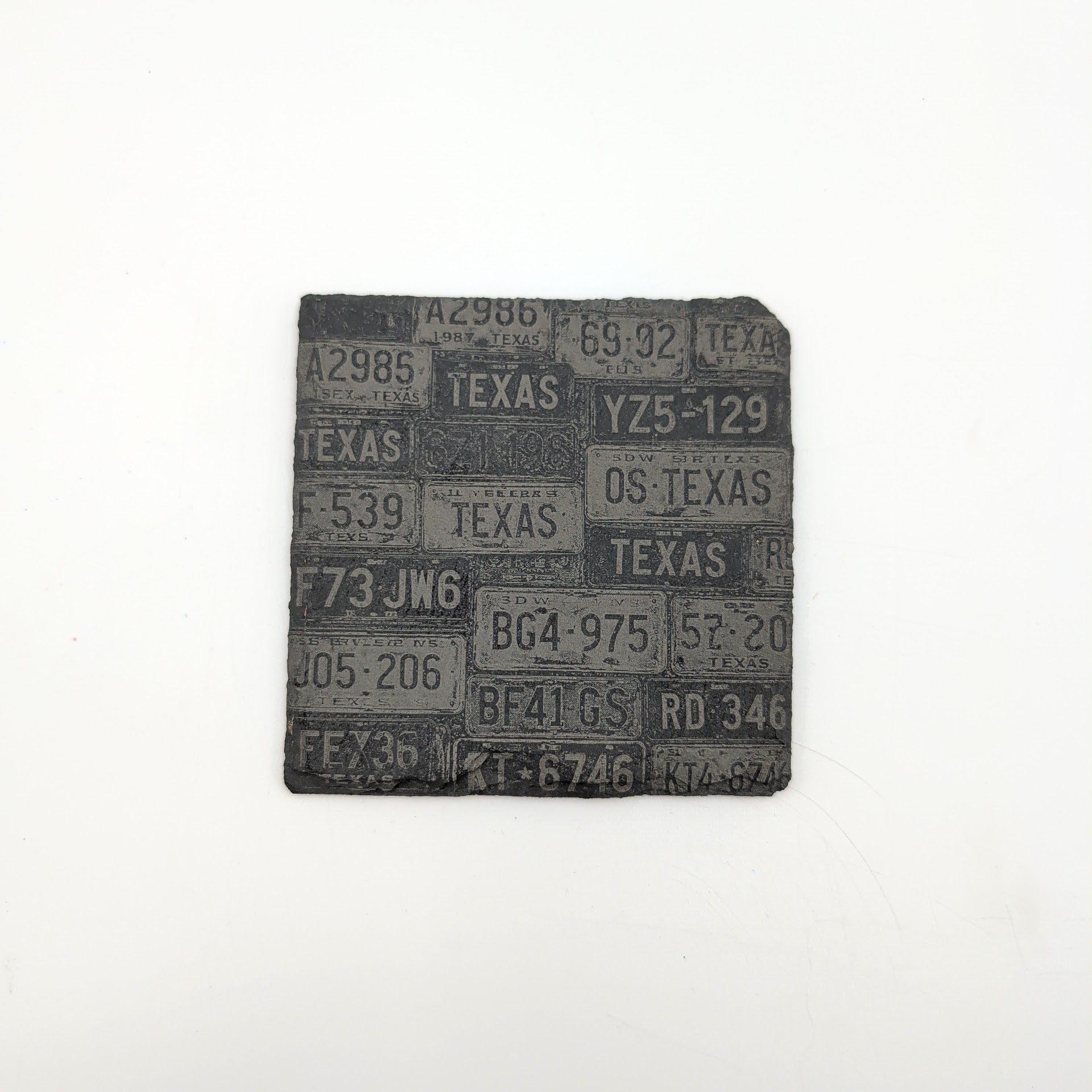 a dark slate coaster with texas style license plates collage