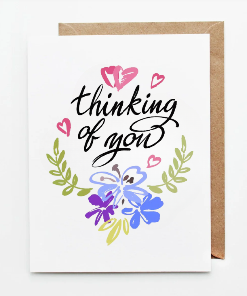 Thinking of you greeting card with hand-lettered text, hearts, and blue floral illustration.