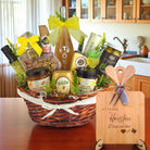 Gift basket filled with Texas treats, preserves, mustard, cheese, sparkling drink, and snacks, with a bamboo board engraved “At Home in Houston, Deep in the Heart of Texas” displayed in a kitchen.