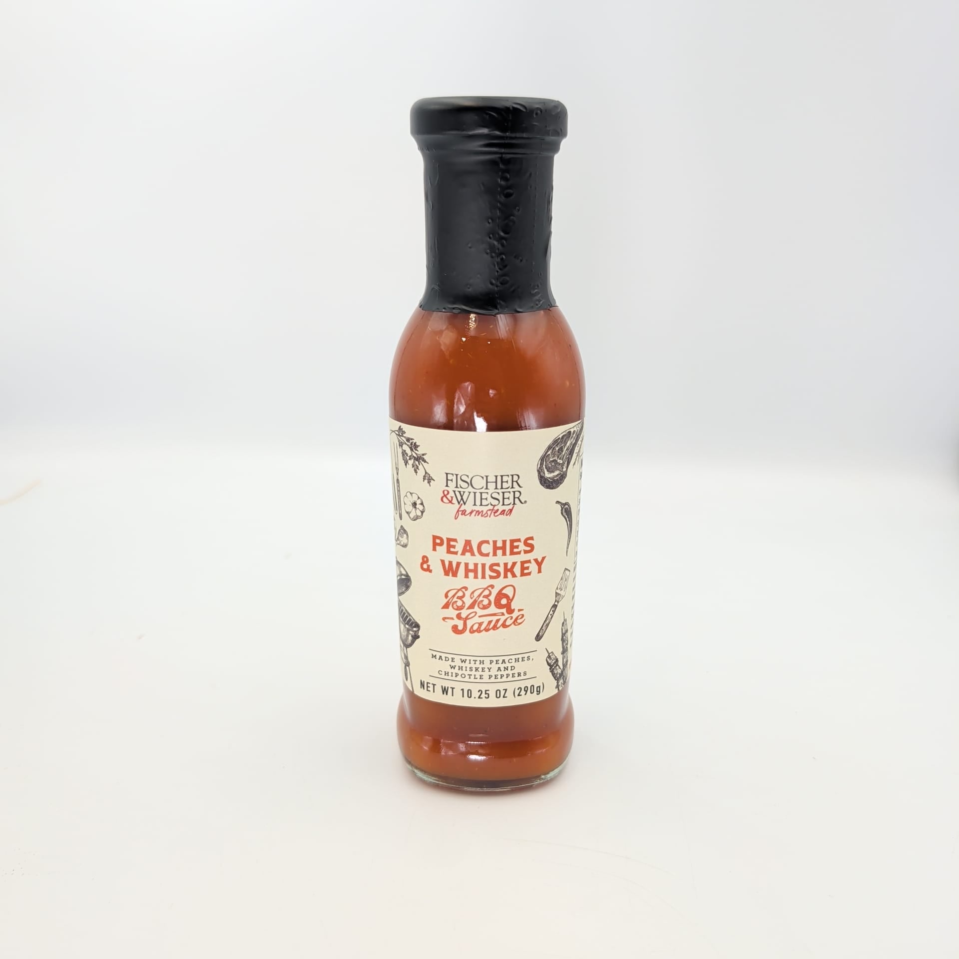 Fischer & Wieser Peaches & Whiskey BBQ Sauce in a glass bottle with a black cap, displayed on a white background for Texas gourmet food gifts and barbecue collections