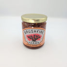 Small-batch Texas peach pepper preserve in a glass jar with a decorative cactus label and gold lid, featured for gourmet gifting and Texas pantry collections