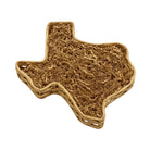 Texas-shaped handwoven wicker gift basket filled with natural kraft paper filler, displayed on a rustic wooden table in a warm home setting.