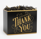 Black thank you gift box with gold lettering and decorative shredded paper filler