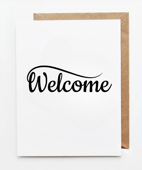 Minimal white greeting card with the word ‘Welcome’ written in black flowing calligraphy, paired with a kraft paper envelope